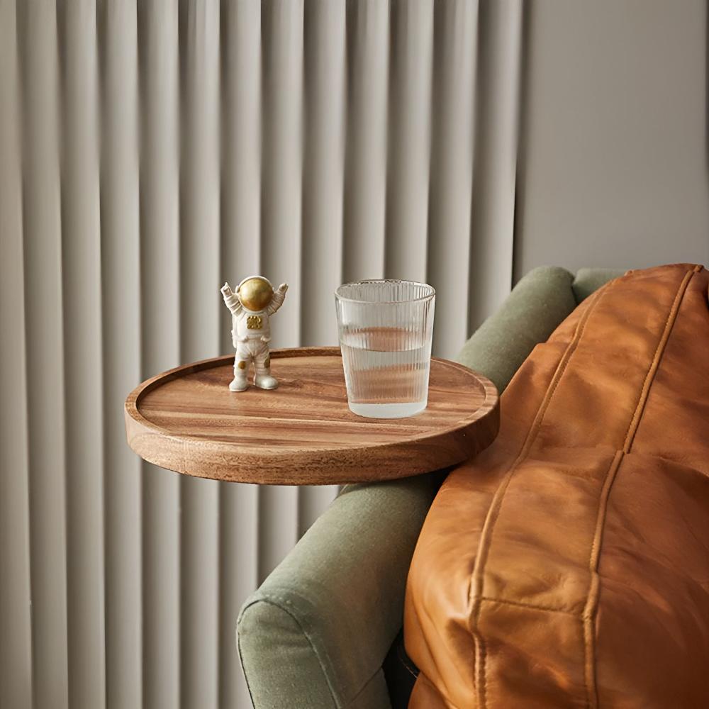 Wood sofa arm tray on a green sofa with a glass of water