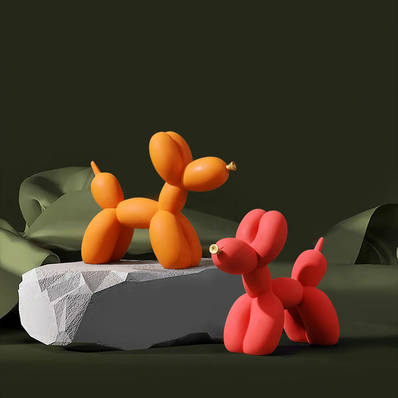Orange and red matte balloon dogs on a stone block