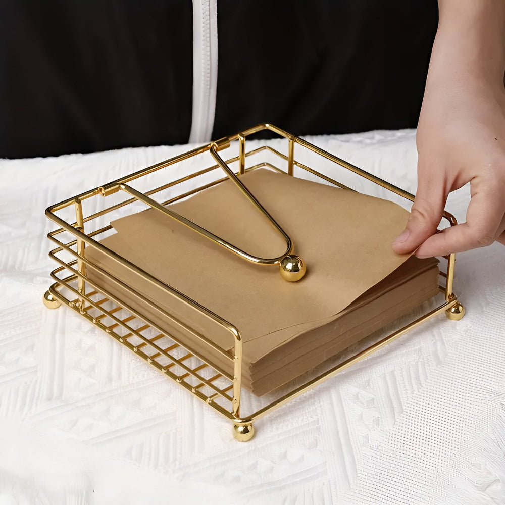 Gold iron napkin holder with paper napkins on a table
