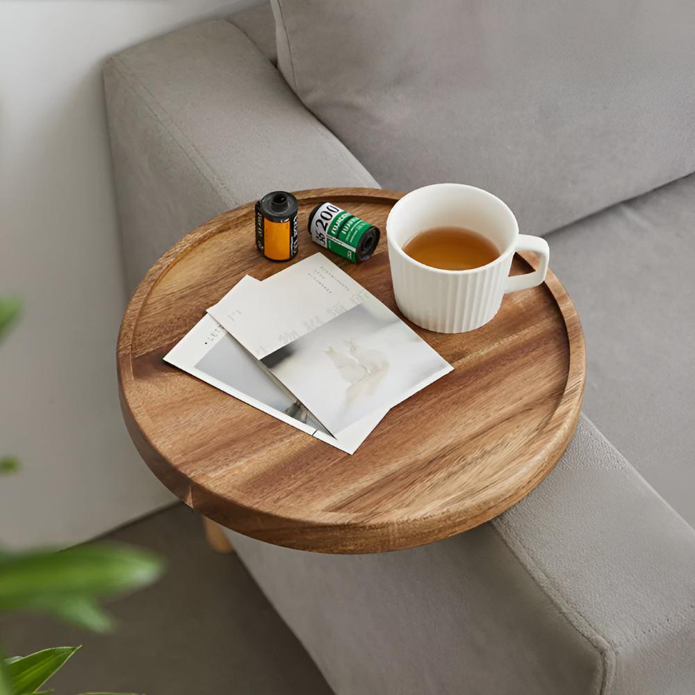 Wood sofa arm tray with tea and a magazine seen from above
