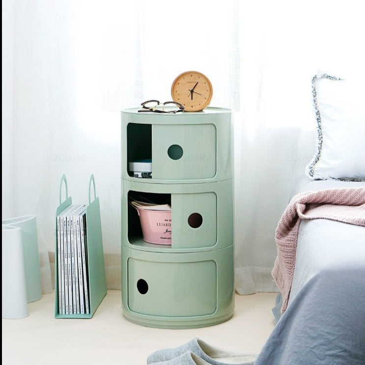 Matcha green round storage unit as a bedside table with one door open