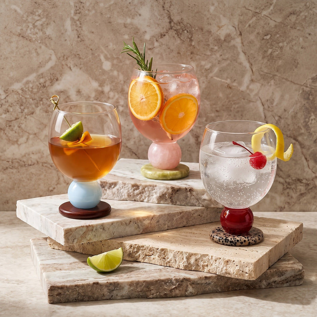 Three stone base glasses with cocktails on stone slabs