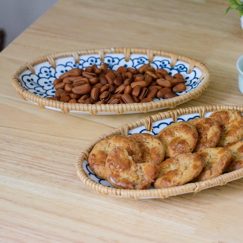 Oval serving plates with almonds and pastries on a wooden table