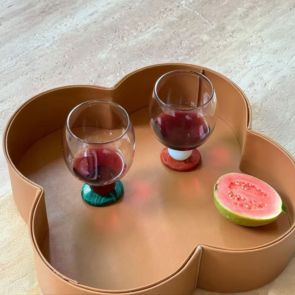 Two stone base glasses on a scalloped wooden tray