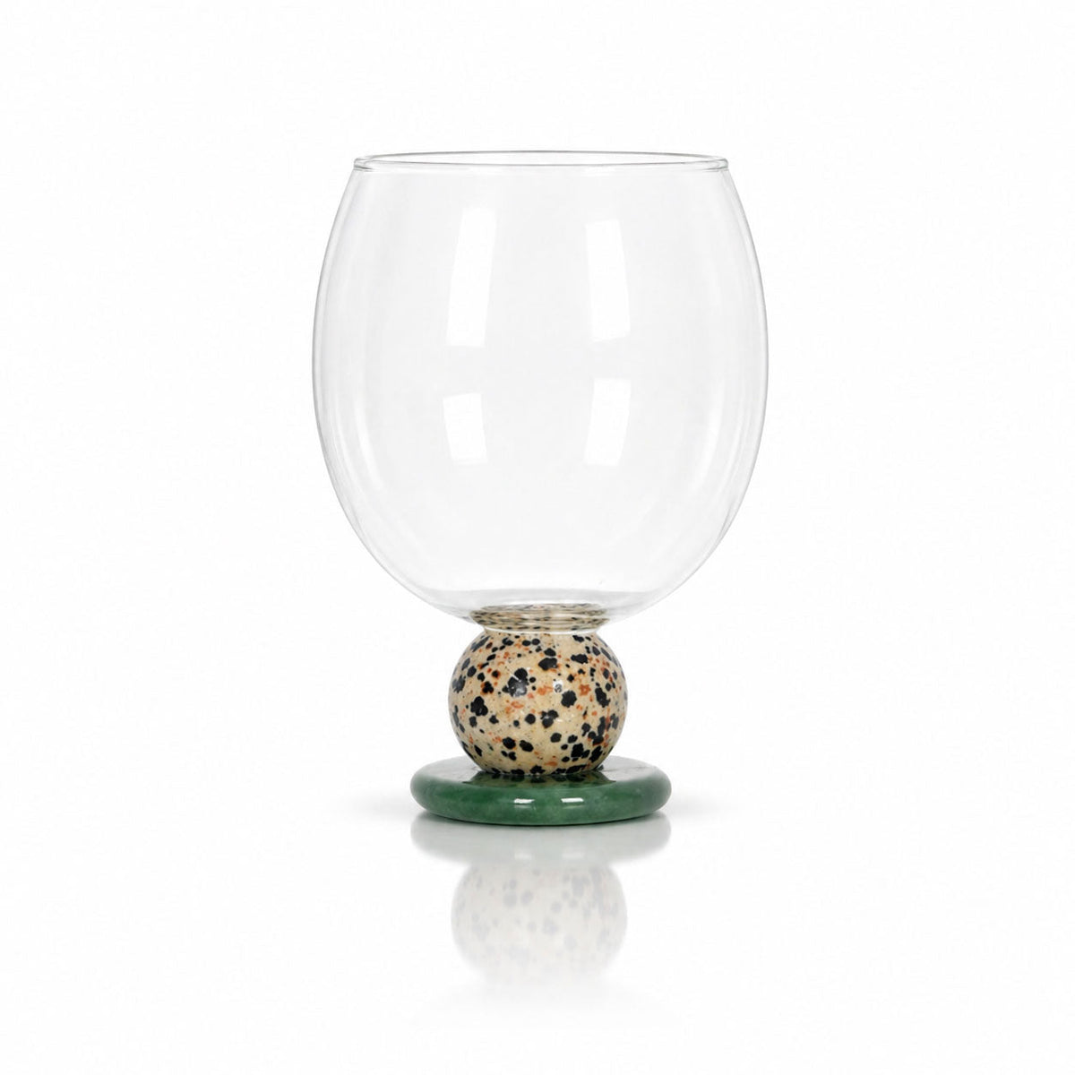 Balloon drinking glass with a speckled stone bead on a green stone base
