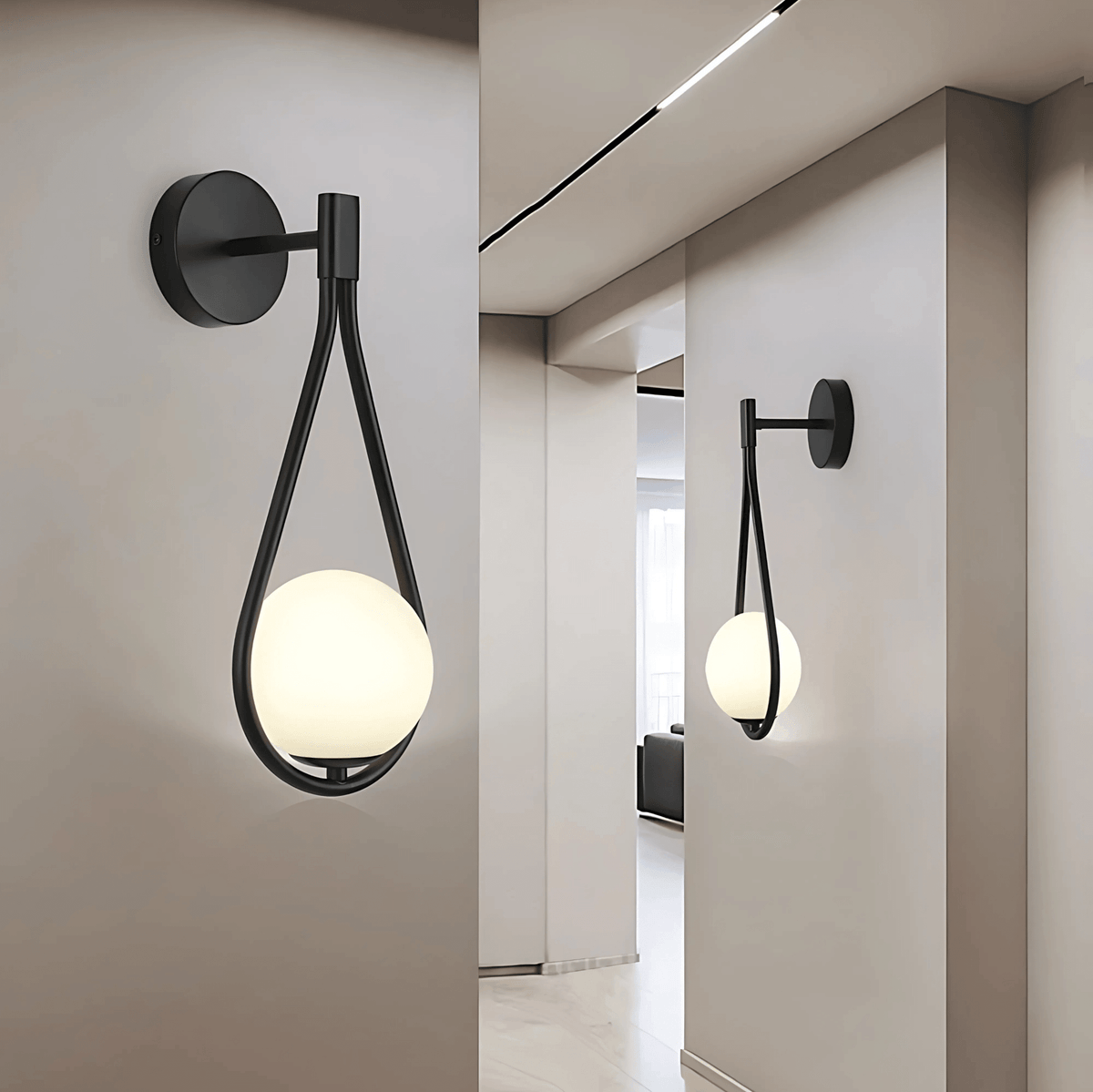 Two black teardrop wall sconces along a hallway wall