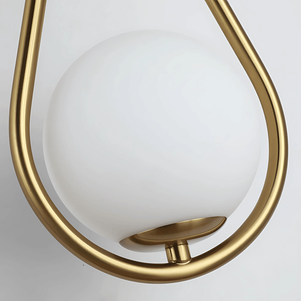 Frosted glass globe resting in the brass cup of the wall sconce frame