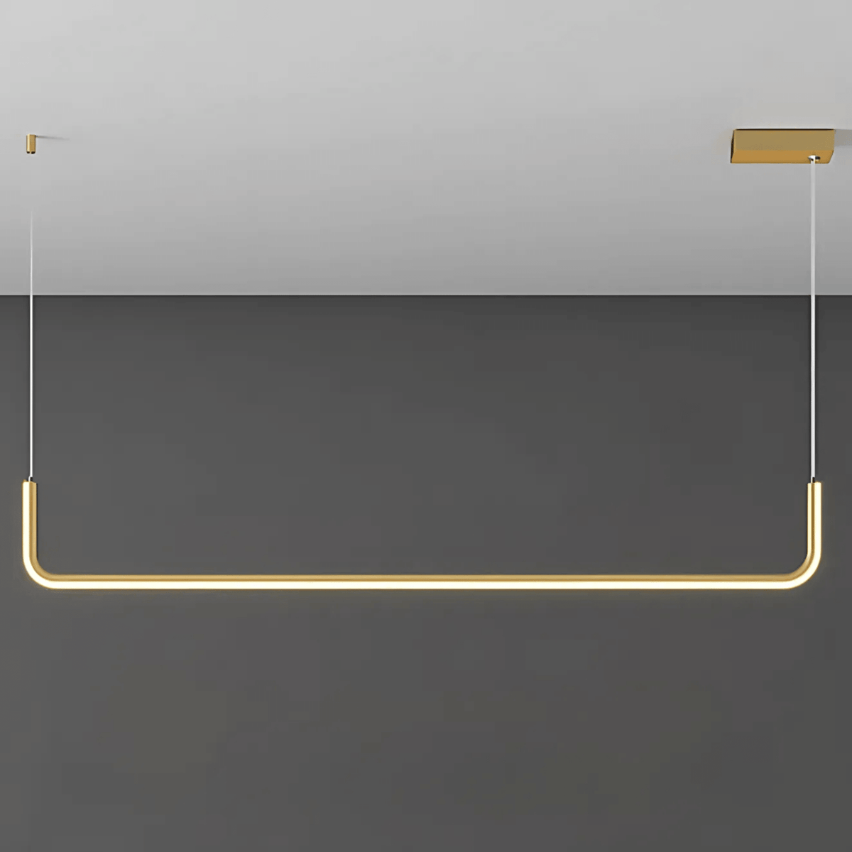 Gold single bar Dumont linear pendant light on a gray wall