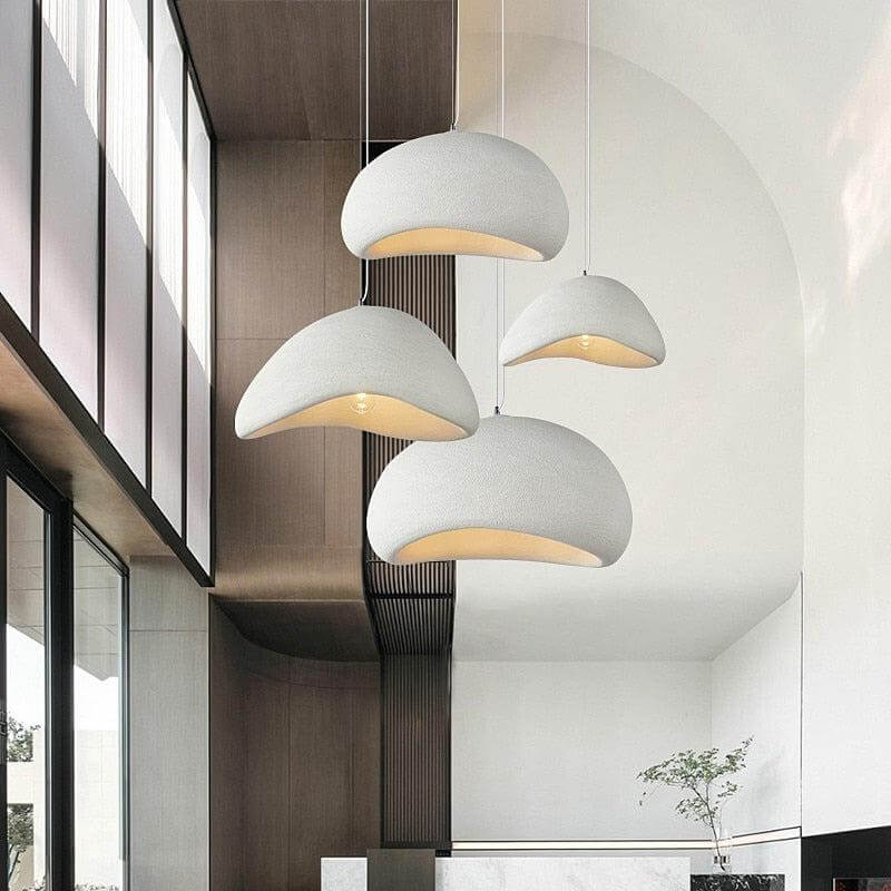 Four white Ginza pendant lights hanging in a tall entry hall