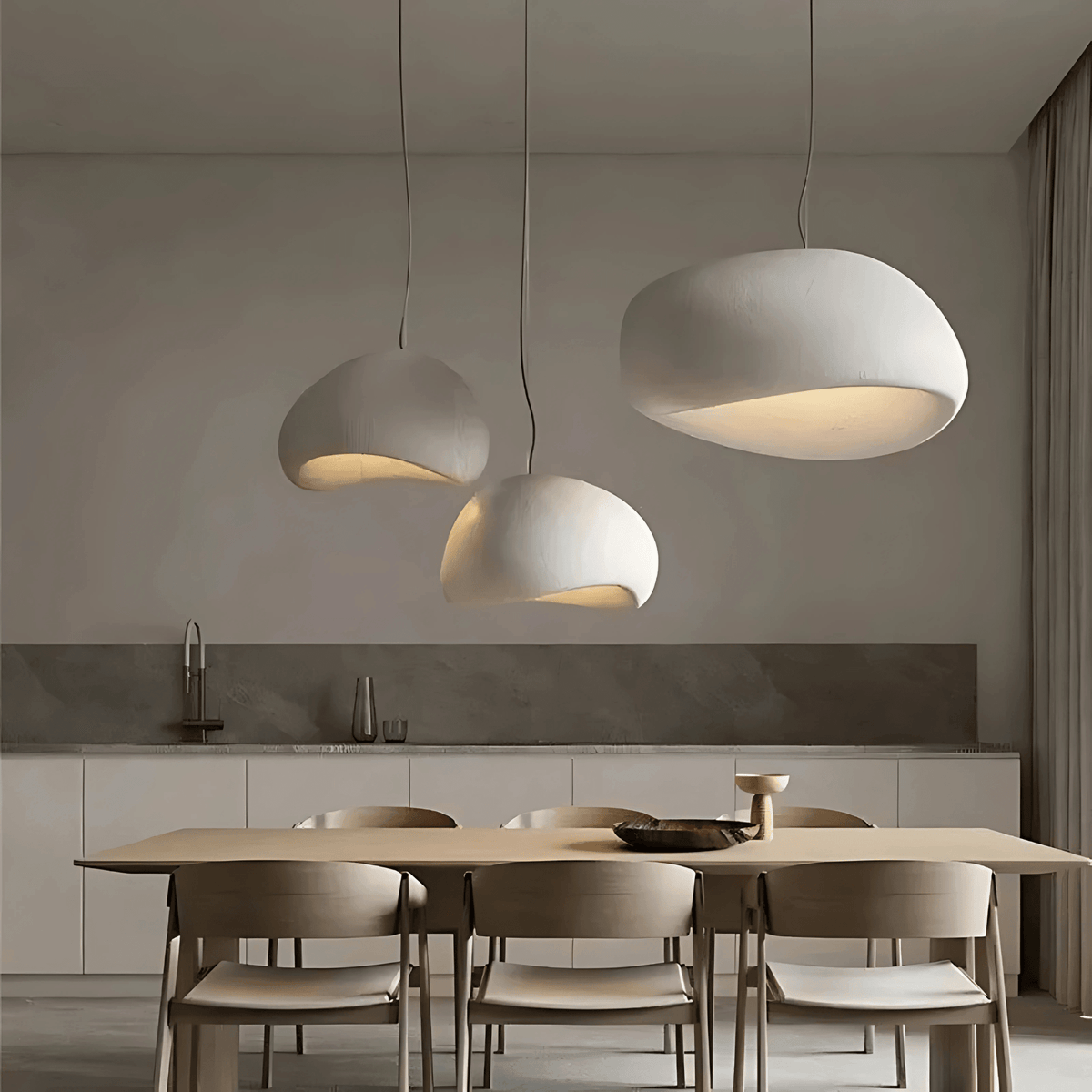 Three white Ginza pendant lights over a wooden dining table