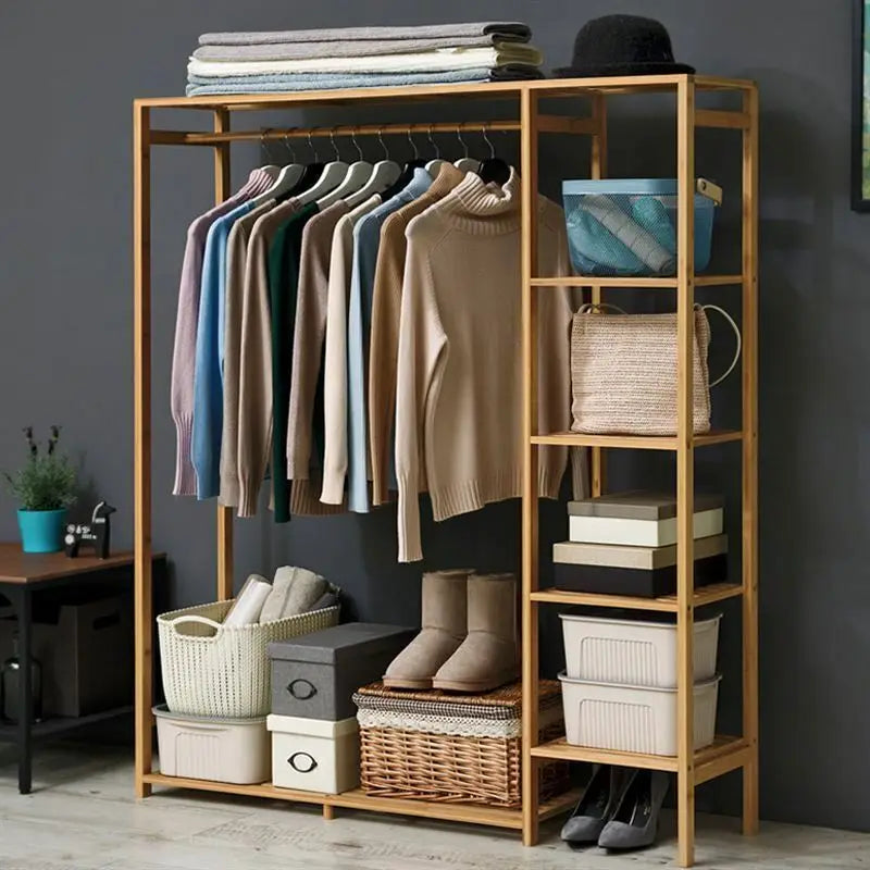 Bamboo garment rack with shirts, baskets and boots against a dark gray wall