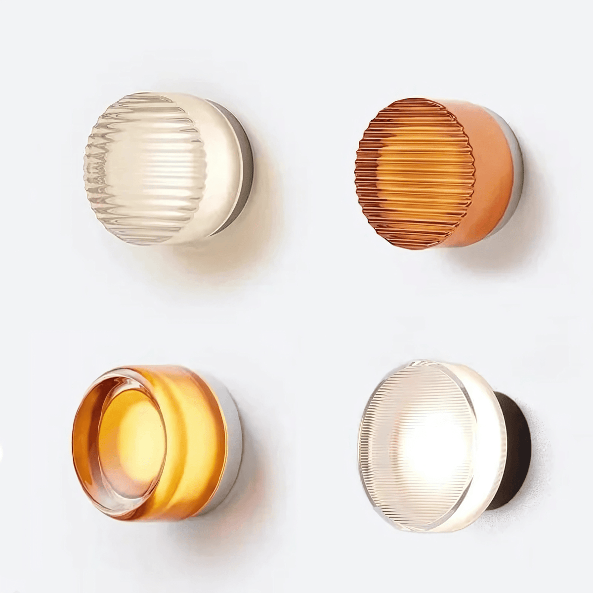 Four Hera glass wall sconces lit on a white wall