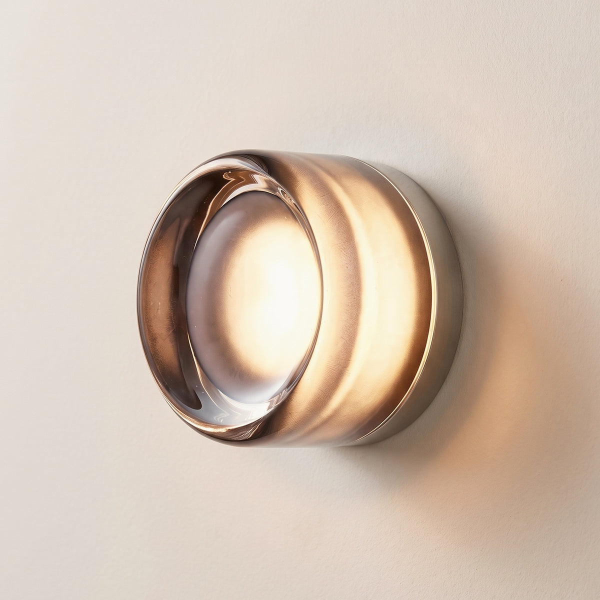 Hera glass wall sconce in Gray, Style B, smoked glass drum on a plaster wall