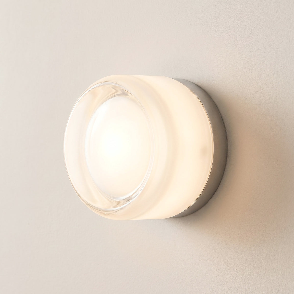 Hera glass wall sconce in White, Style B, smooth glass drum on a plaster wall