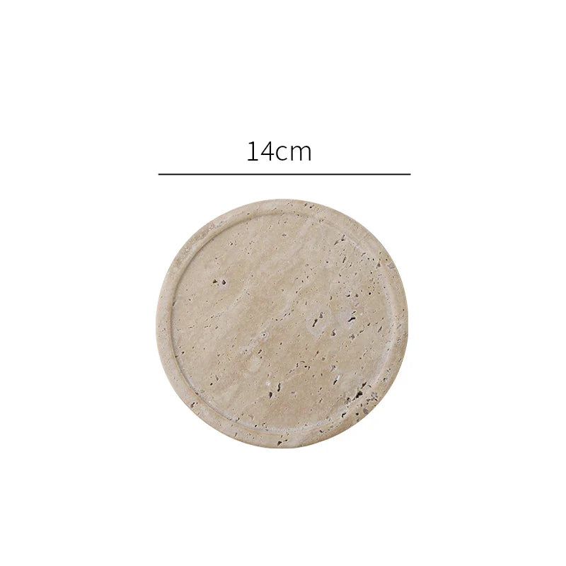 Small round travertine tray seen from above on white
