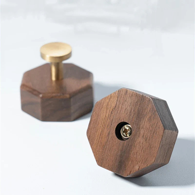 Back of the walnut hook block next to a hook with its brass peg