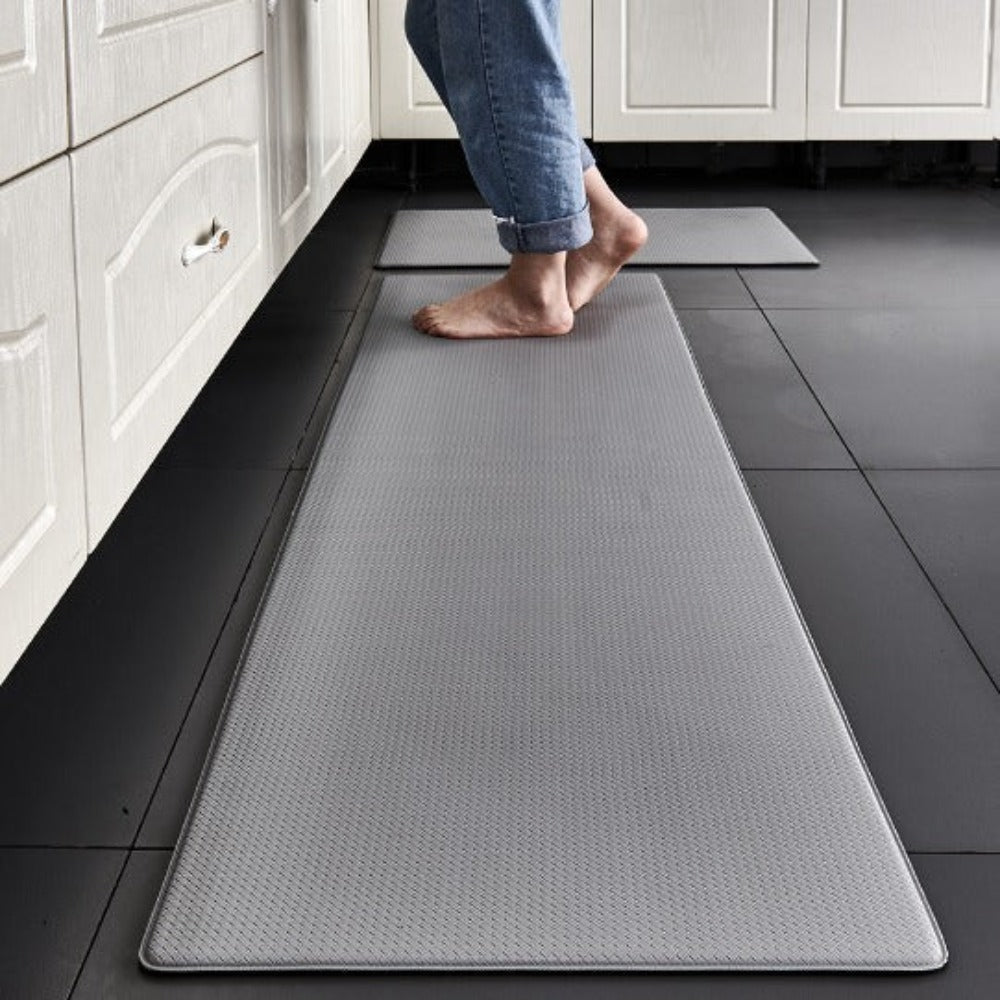 Anti-fatigue kitchen mat in Light Gray in front of white cabinets