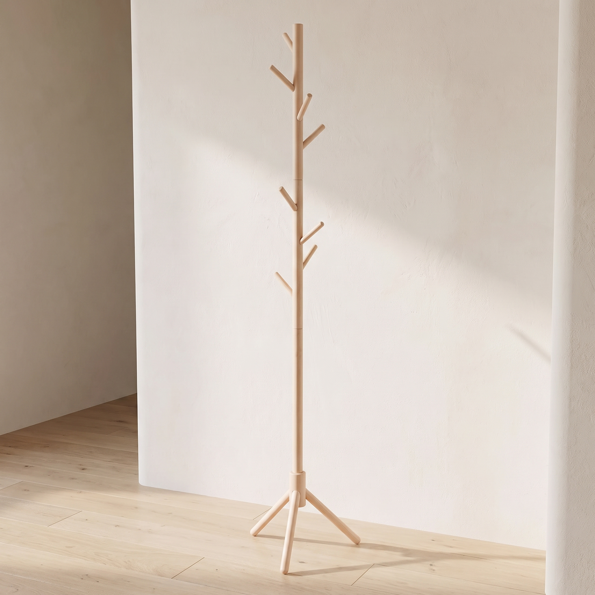 Natural wood tree coat stand on a tripod base in a bright room