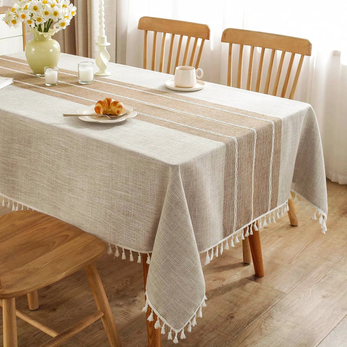 Close view of the woven stripe band and tassels on an oatmeal tablecloth