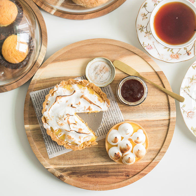 Wood serving board with a lemon tart and meringues