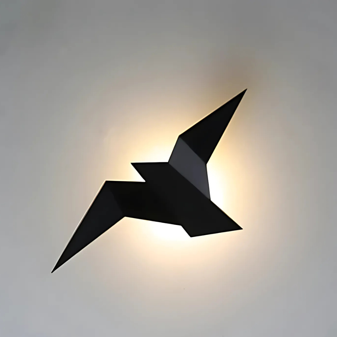 Origami bird LED wall light in black, lit on a gray wall