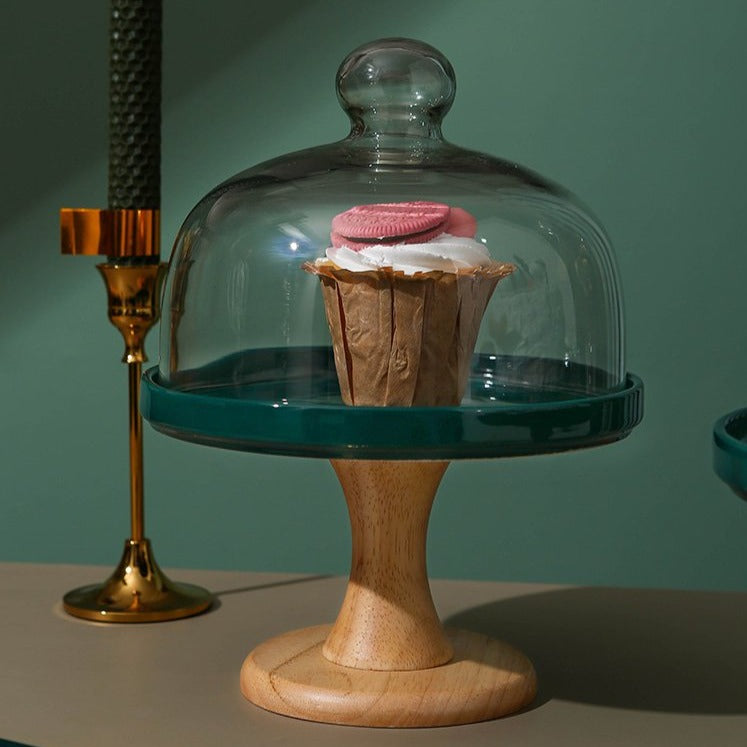 Green footed cake stand with a glass dome and a cupcake