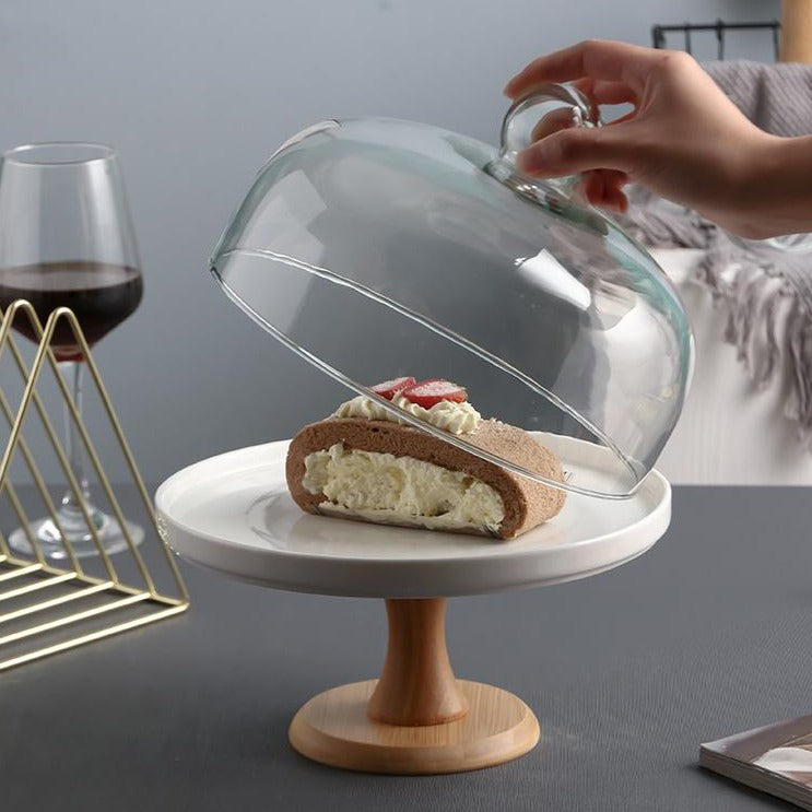 White footed cake stand with a glass dome and a slice of cake