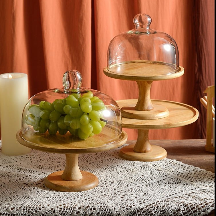 Footed wood cake stands with glass domes holding grapes