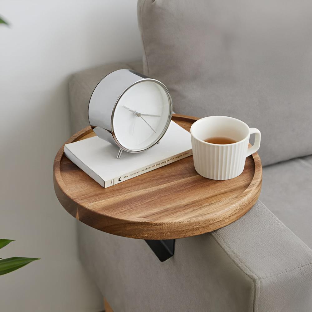 Wood sofa arm tray with a clock, a book and a cup of tea