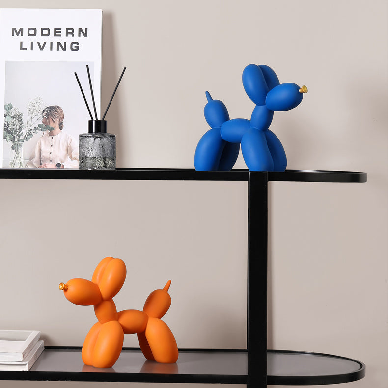 Blue and orange matte balloon dogs on a black shelf