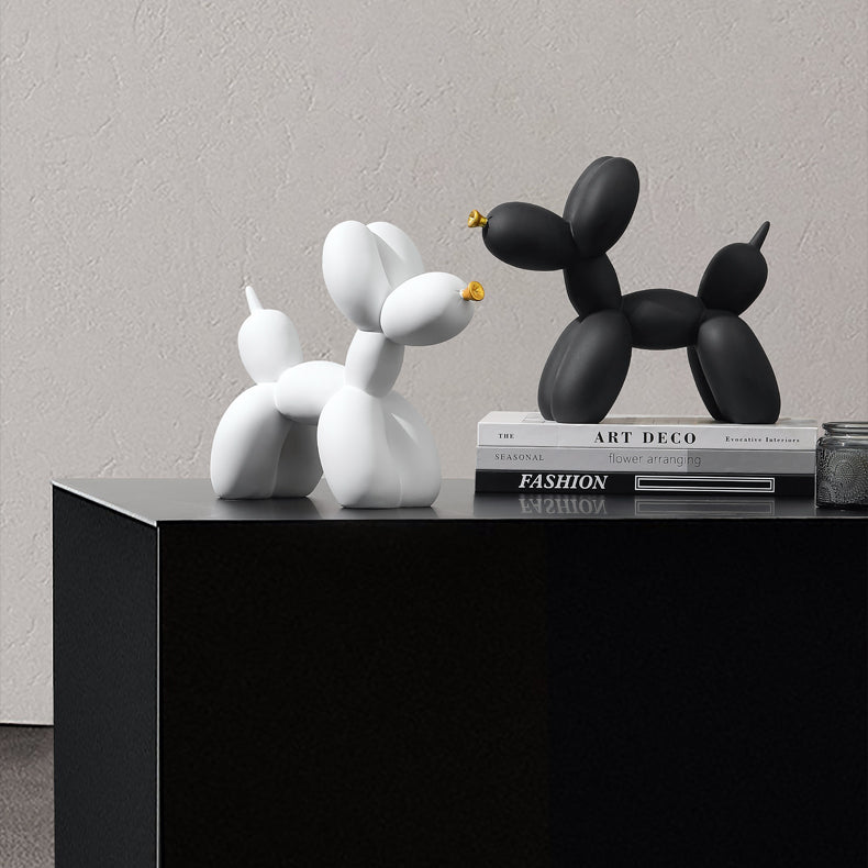 White and black matte balloon dogs on a black side table