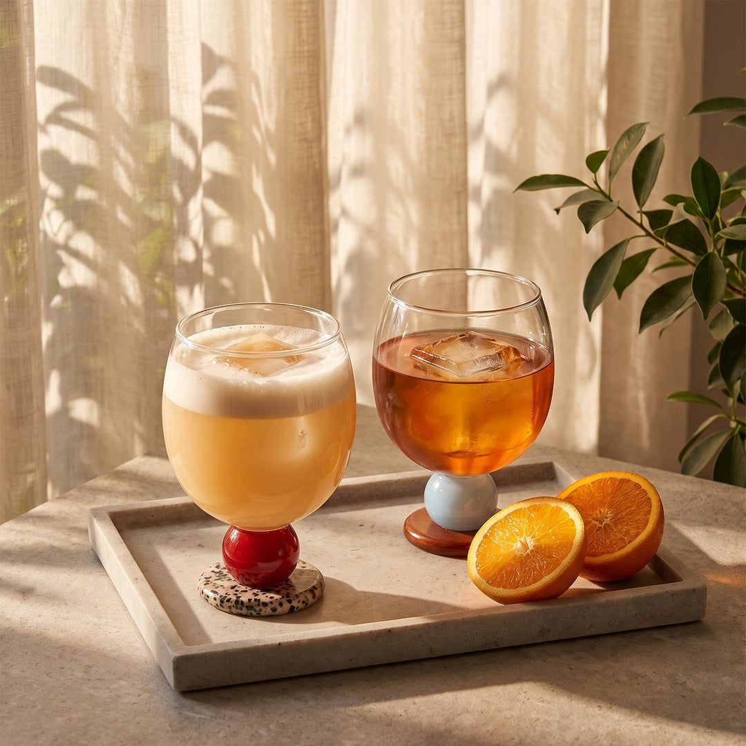 Two stone base glasses with orange drinks on a stone tray