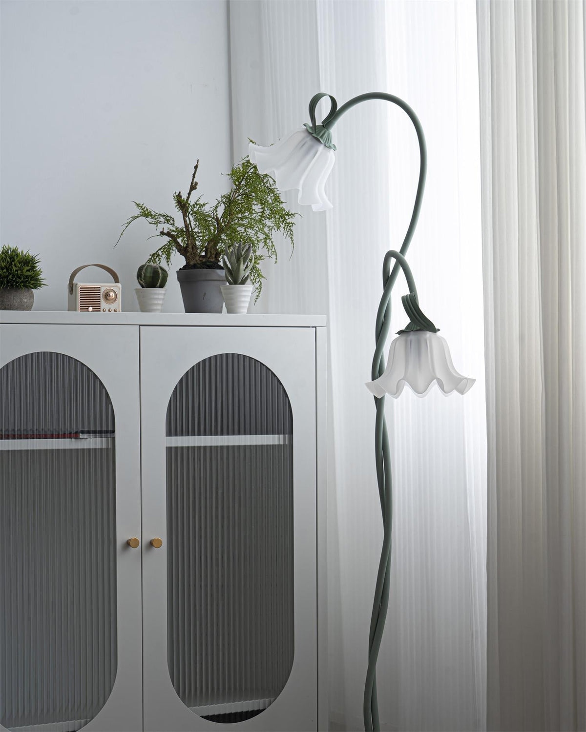Calla lily floor lamp, green stem white shades - wide interior view, warm light