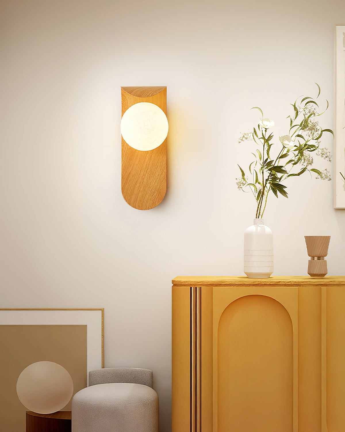 Carlyle wall lamp with frosted glass globe in a bright living room setting