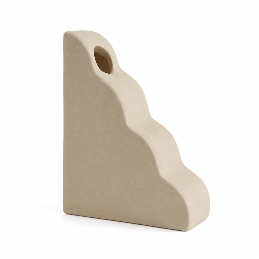Curved matte unglazed ceramic vase on a dining table