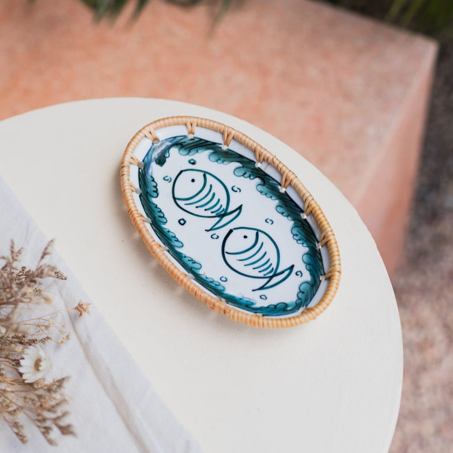Oval serving plate with the fish pattern on a white table