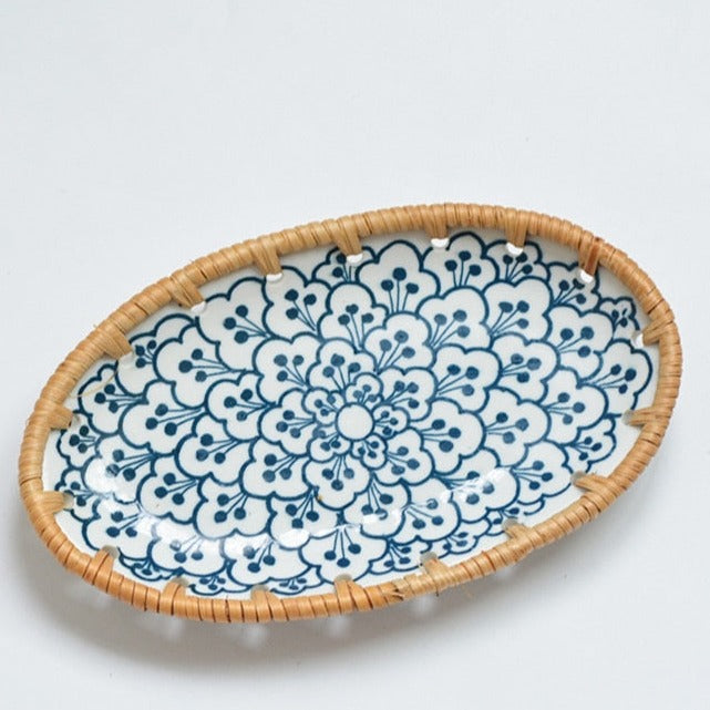 Oval ceramic serving plate with a blue flower pattern in a woven rim