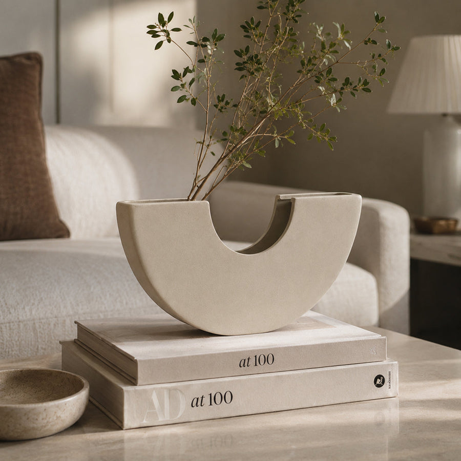 Matte unglazed ceramic vase with a sculptural arch silhouette on a tabletop