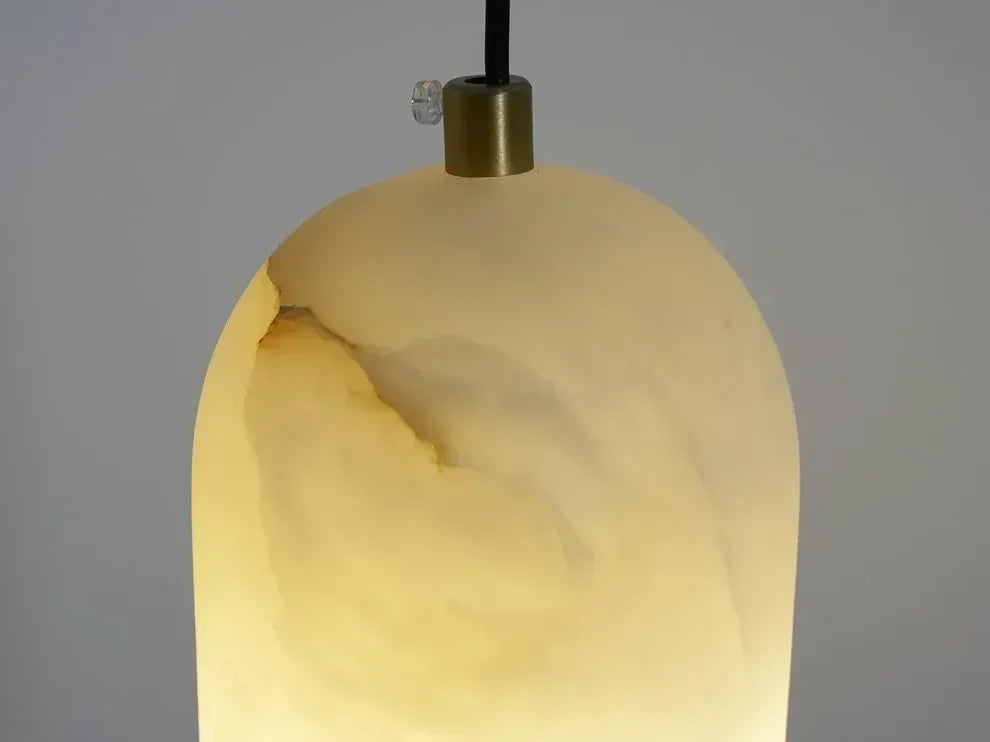 Close-up of the lit alabaster shade showing its veining and the brass cap