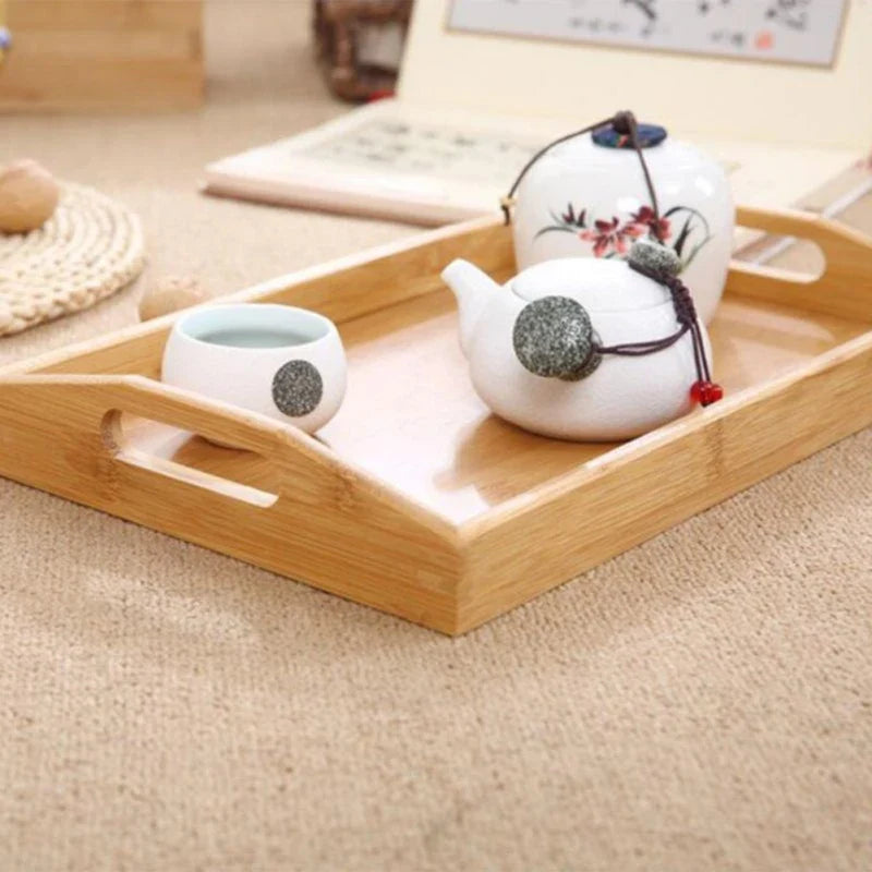 Bamboo tray holding a white teapot and cup on a rug