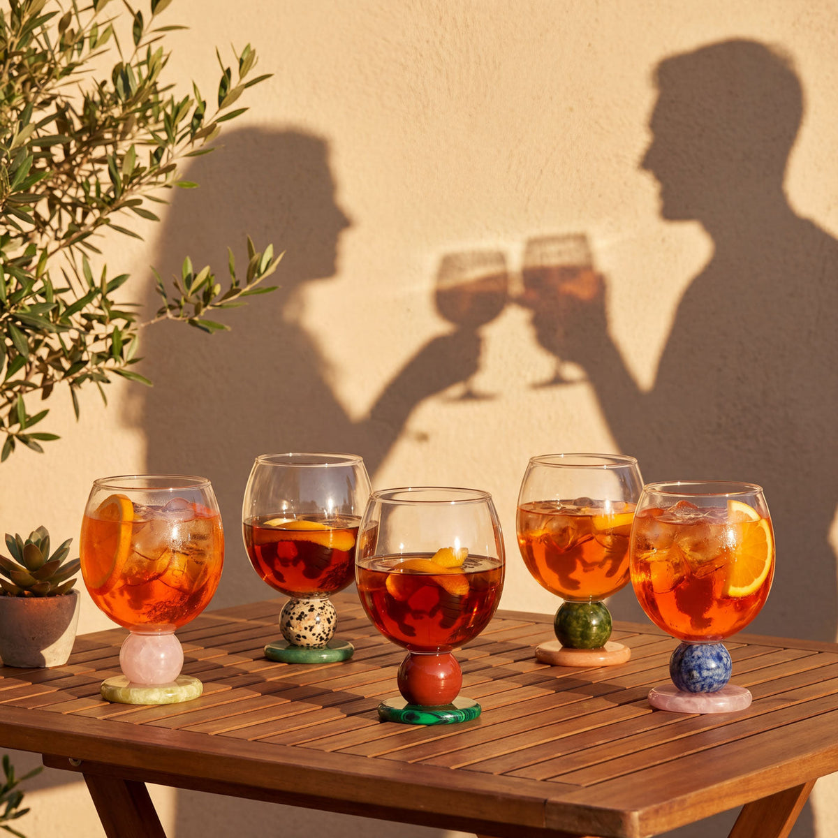 Stone base glasses with drinks and a toast in the background