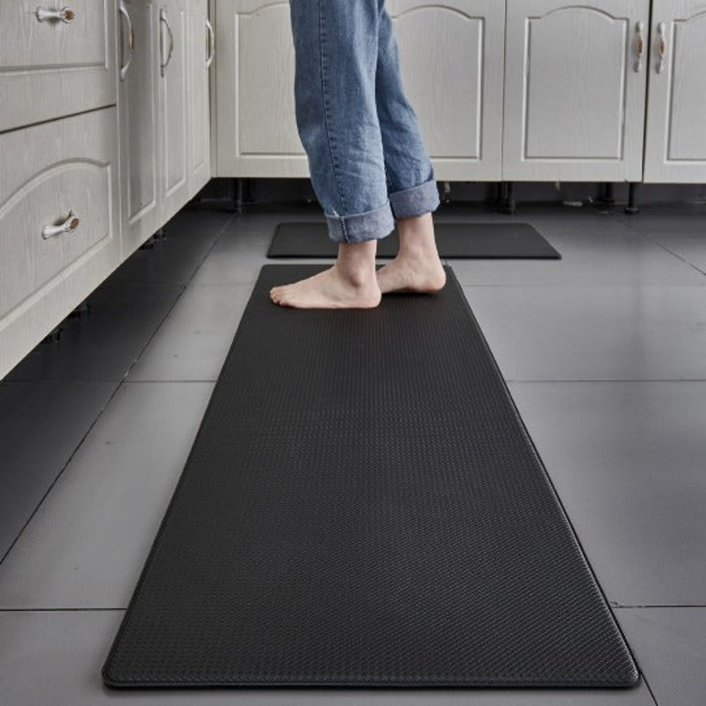 Anti-fatigue kitchen mat in Black in front of white cabinets