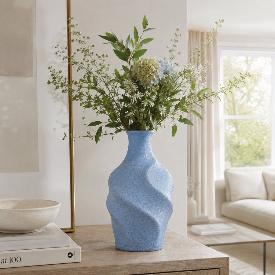 Blue twisted ceramic vase with a fluid sculptural silhouette