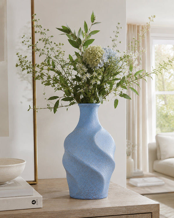 Blue twisted ceramic vase with a fluid sculptural silhouette