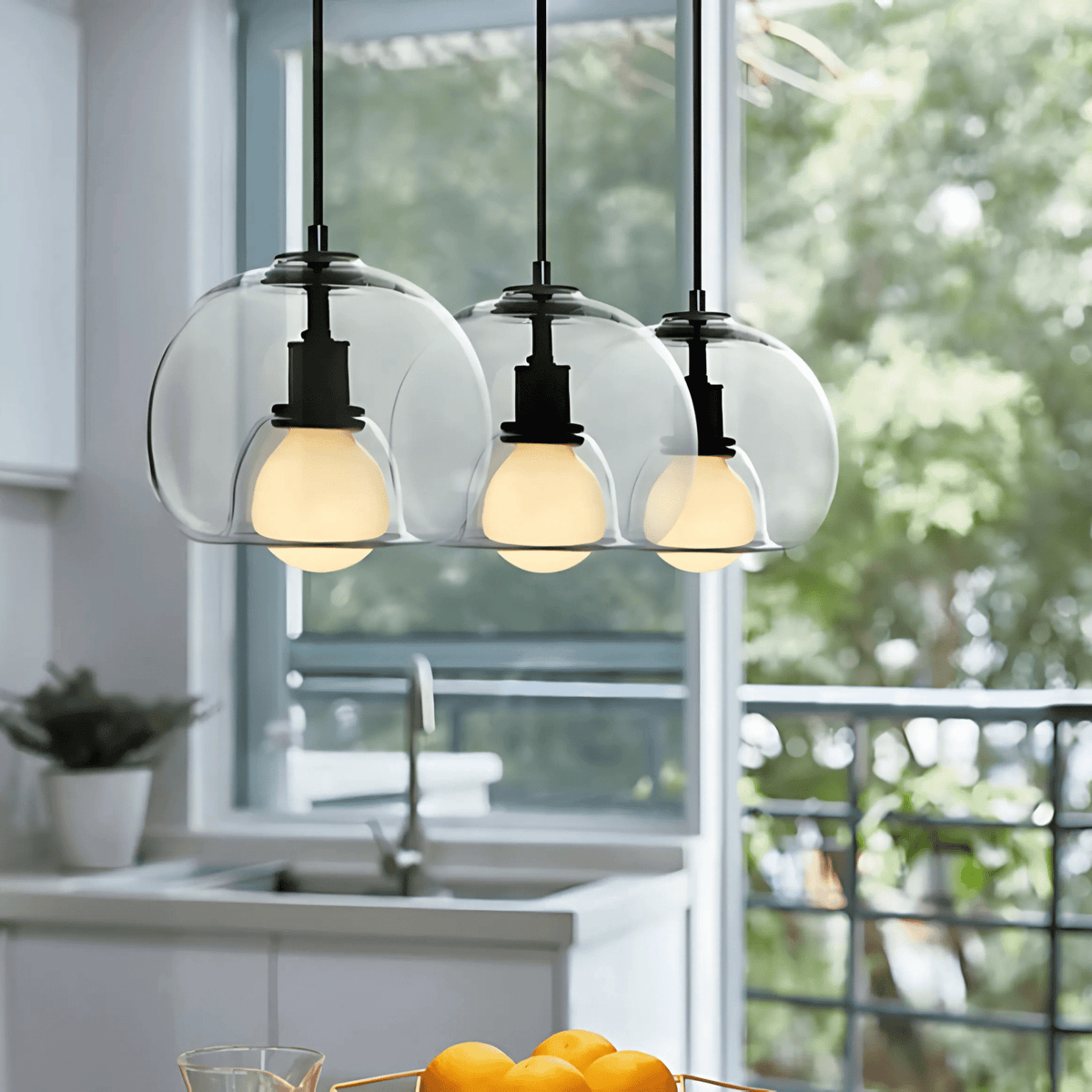 Three clear Clyde pendant lights in front of a kitchen window