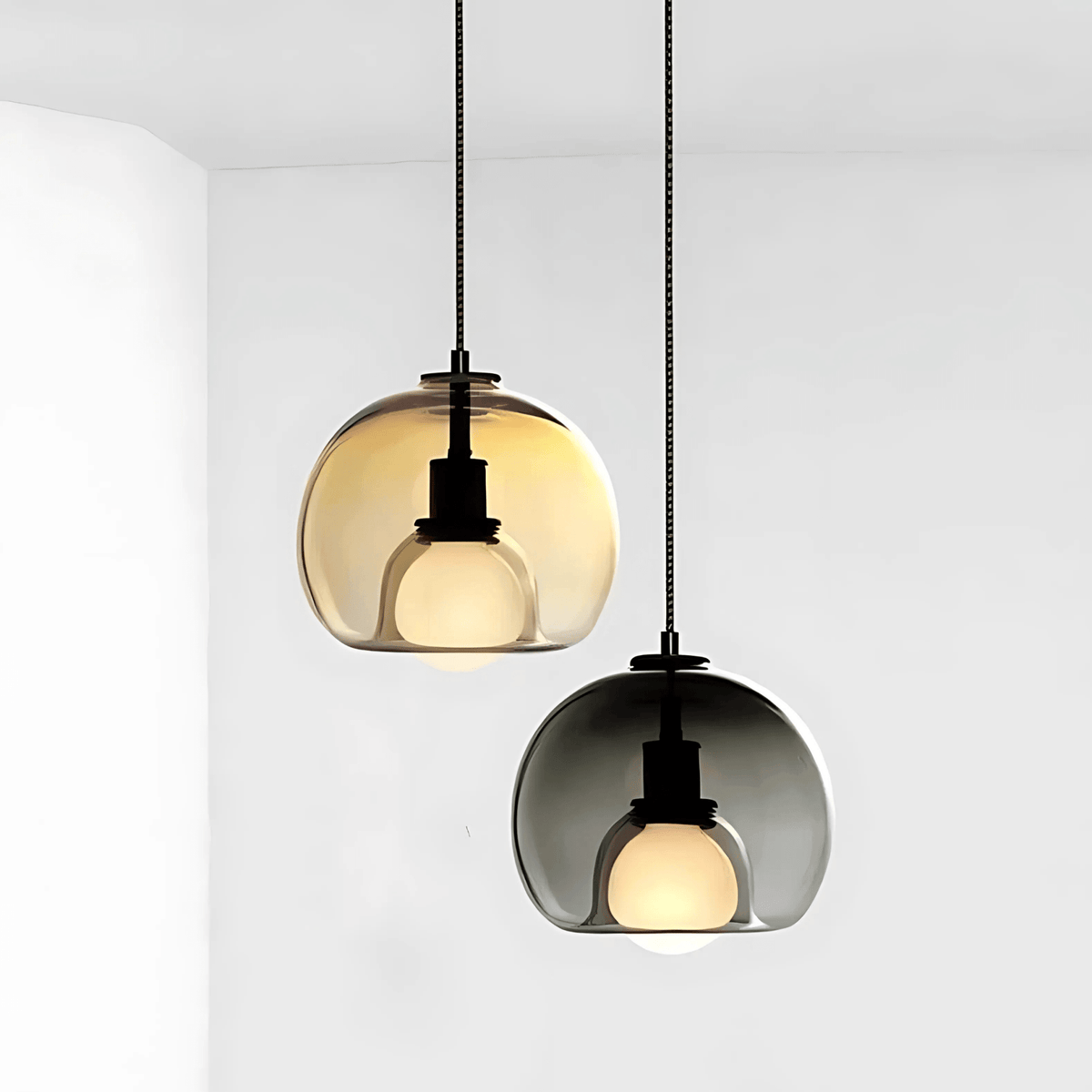 Amber and smoke gray Clyde glass pendant lights on a white wall