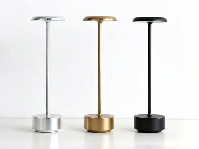 Three cordless table lamps in silver, gold and black on a white surface