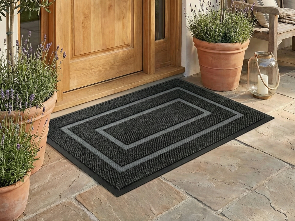 Black doormat with gray frame lines in front of a wooden front door