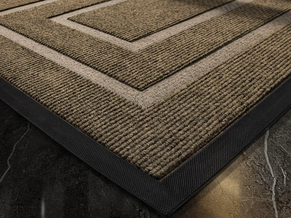 Close up of the brown doormat with its ribbed fiber surface and black rubber edge
