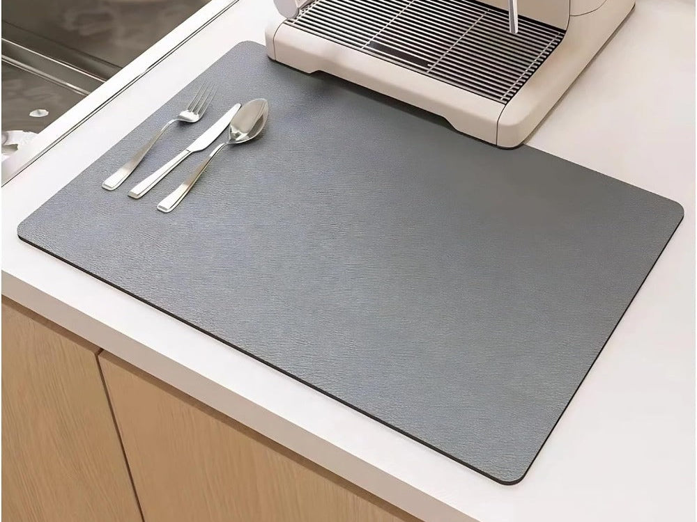 Gray dish drying mat on a kitchen counter under a coffee maker, next to the sink